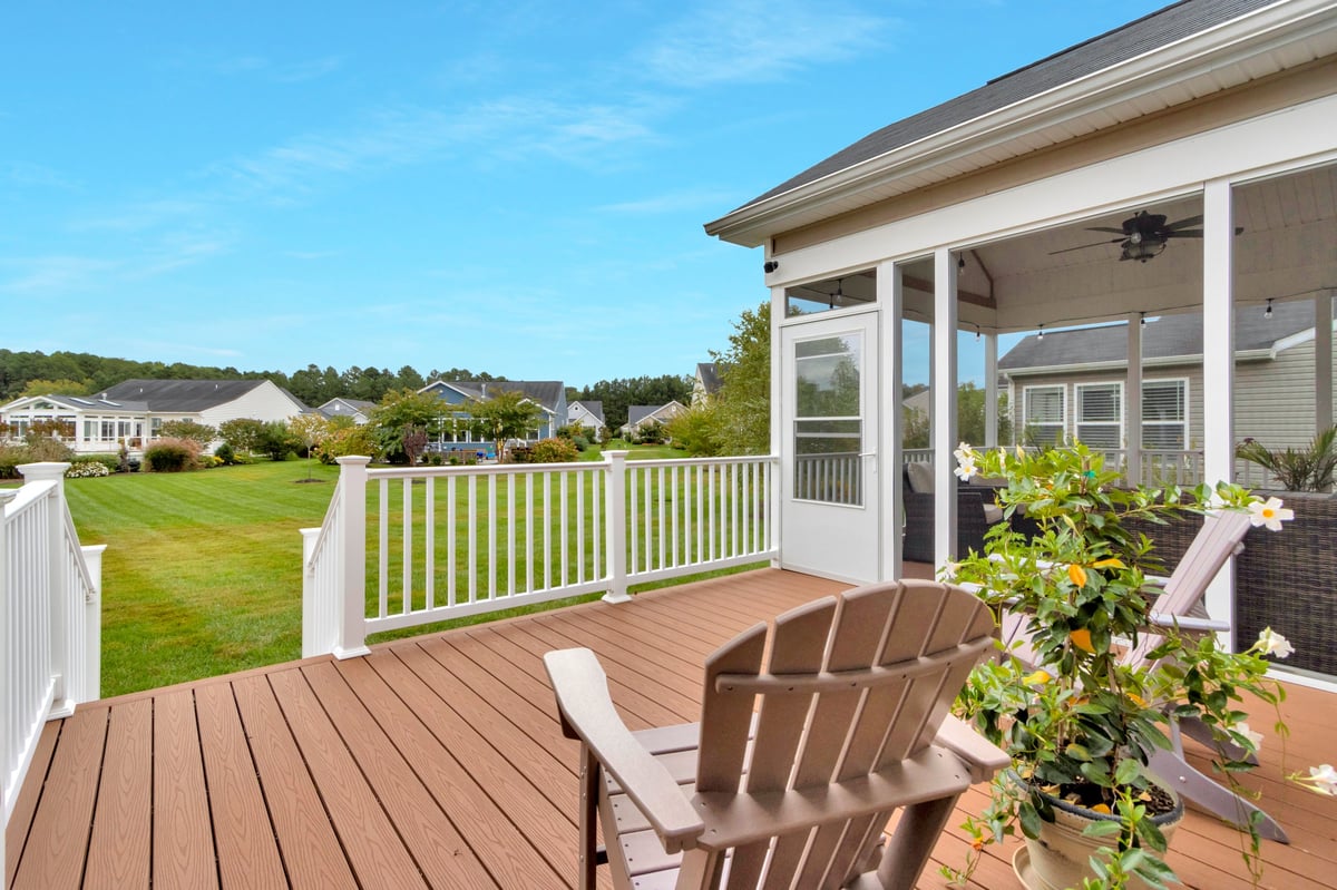 Wood deck with Adirondack chairs overlooking green space